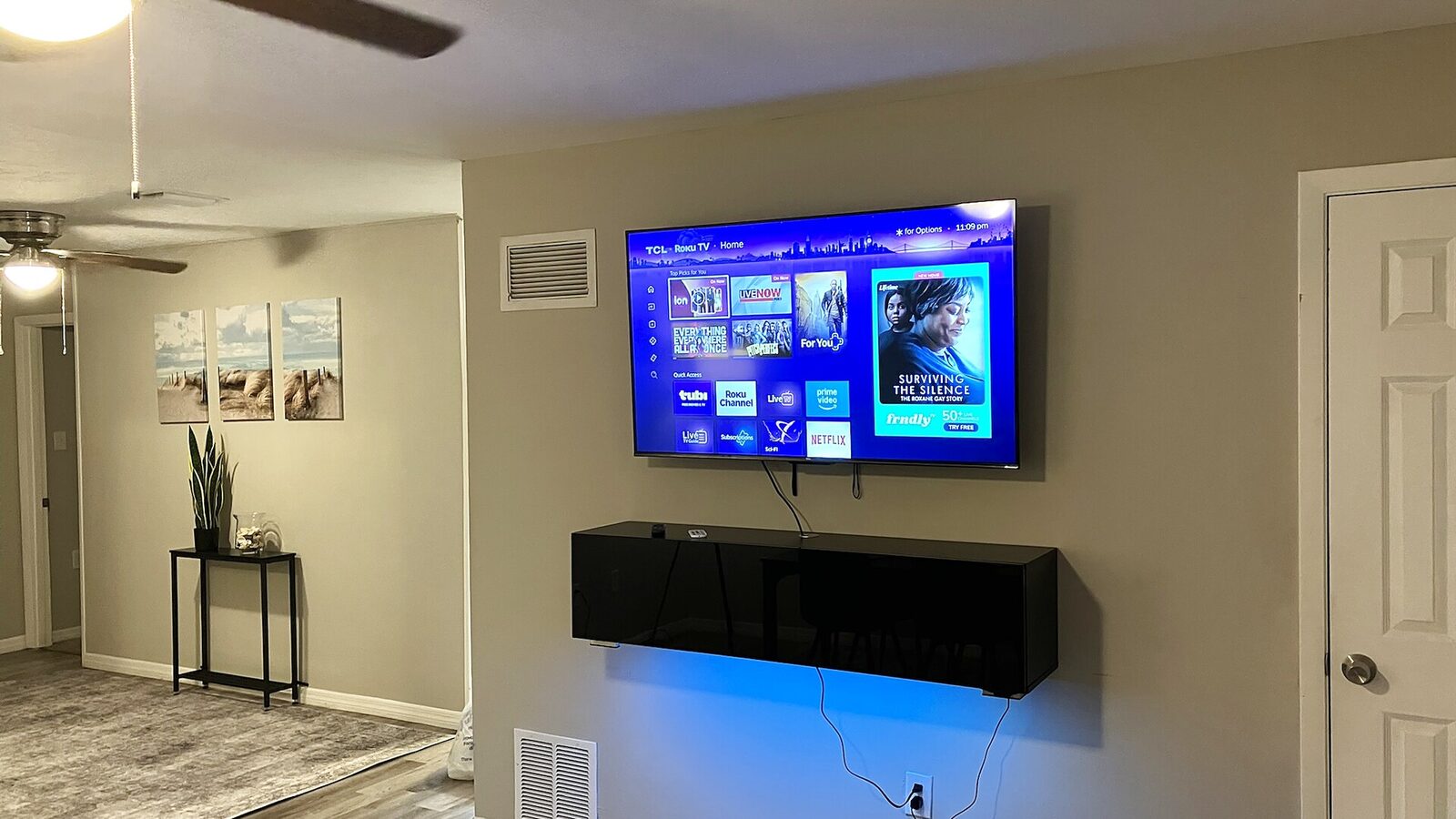 Sarasota furnished living room with wall-mounted television and ceiling fan