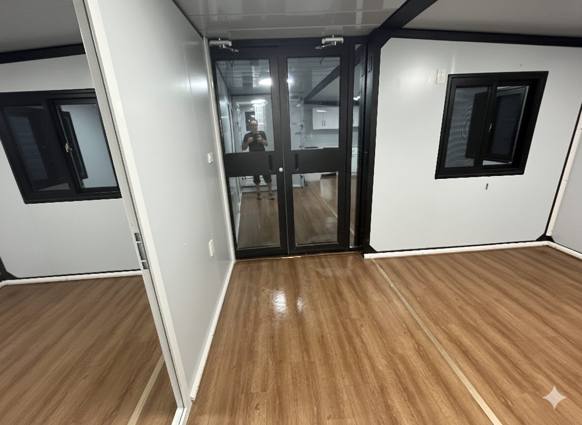 Glass entry door and black-framed windows inside the Comanche container tiny home